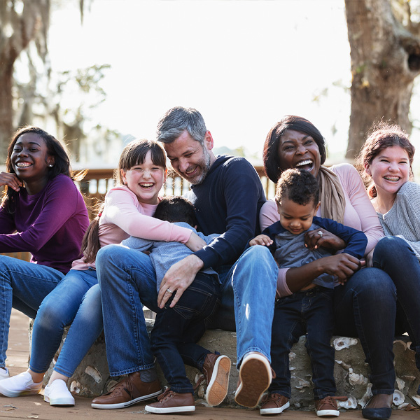 A multi-ethnic blended family playing in the park together on a sunny day