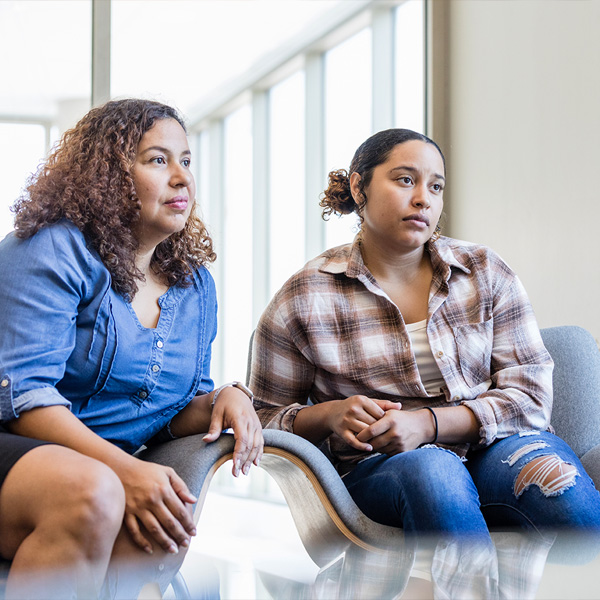 teen and mother sitting on chairs